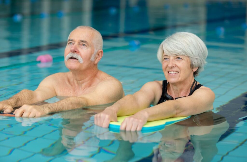 A couple of happy seniors doing a water aerobics class.