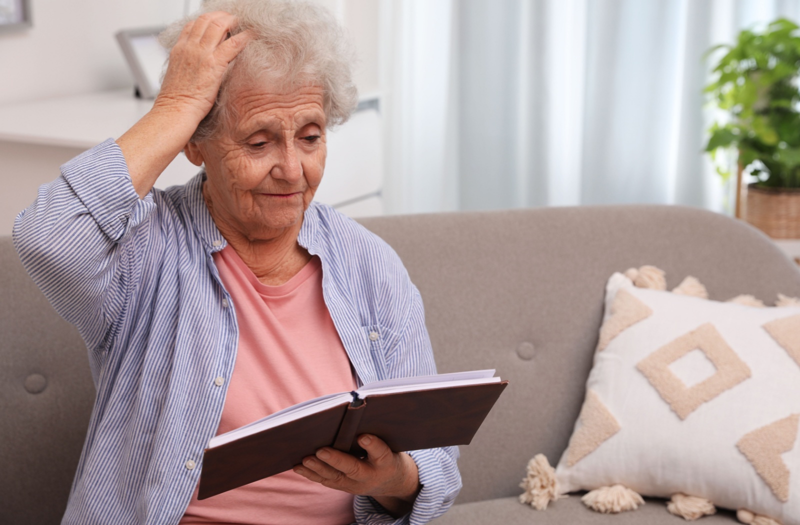 A senior holding a day planner puts a hand to their head, confused about events they’ve forgotten about on their calendar